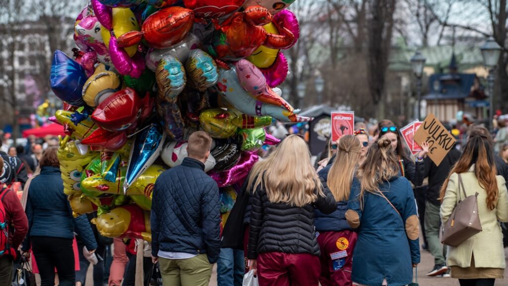 A large bunch of colorful balloons at an outdoor event.